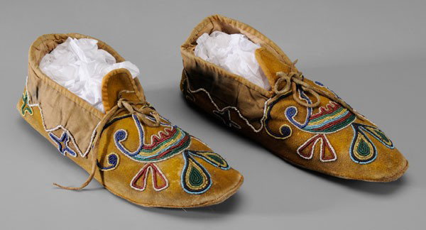Native American Beaded Moccasins: possibly Cree Indian or Great Lakes area, late 19th/early 20th century, yellow-dyed buckskin with cotton fabric trim, lining and cuffs with traces of blue dye, beaded geometric designs and zigzag acce
