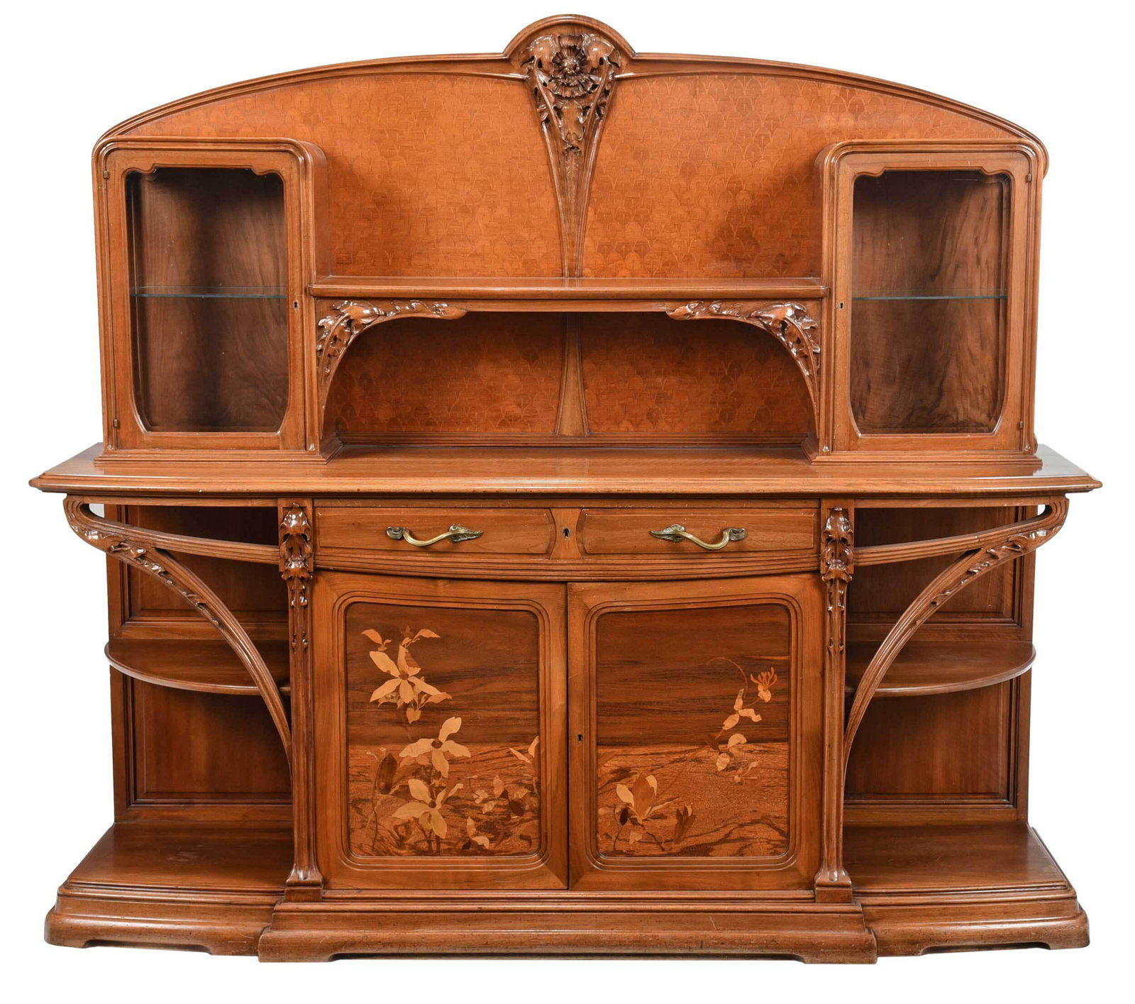 Majorelle Art Nouveau Marquetry Inlaid "Chicoree" Sideboard: French, circa 1900, figured walnut with inlaid exotic woods, with inlaid arched crest centering a deeply carved leaf and flower applique, over carved shelf supports flanked by two beveled door cabinet