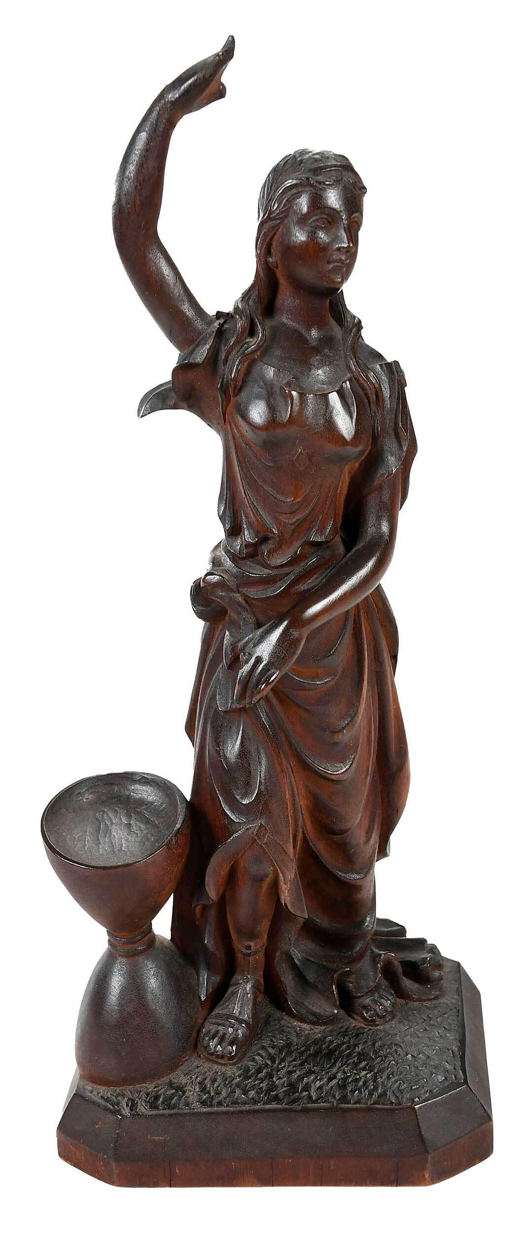 Continental Carved Wood Figure of a Woman: 19th century, woman in dress and sandals with arms raised, on elongated octagonal base, 14 x 6 x 5 in. Provenance: The Estate of Peter H. Tillou, Litchfield, Connecticut