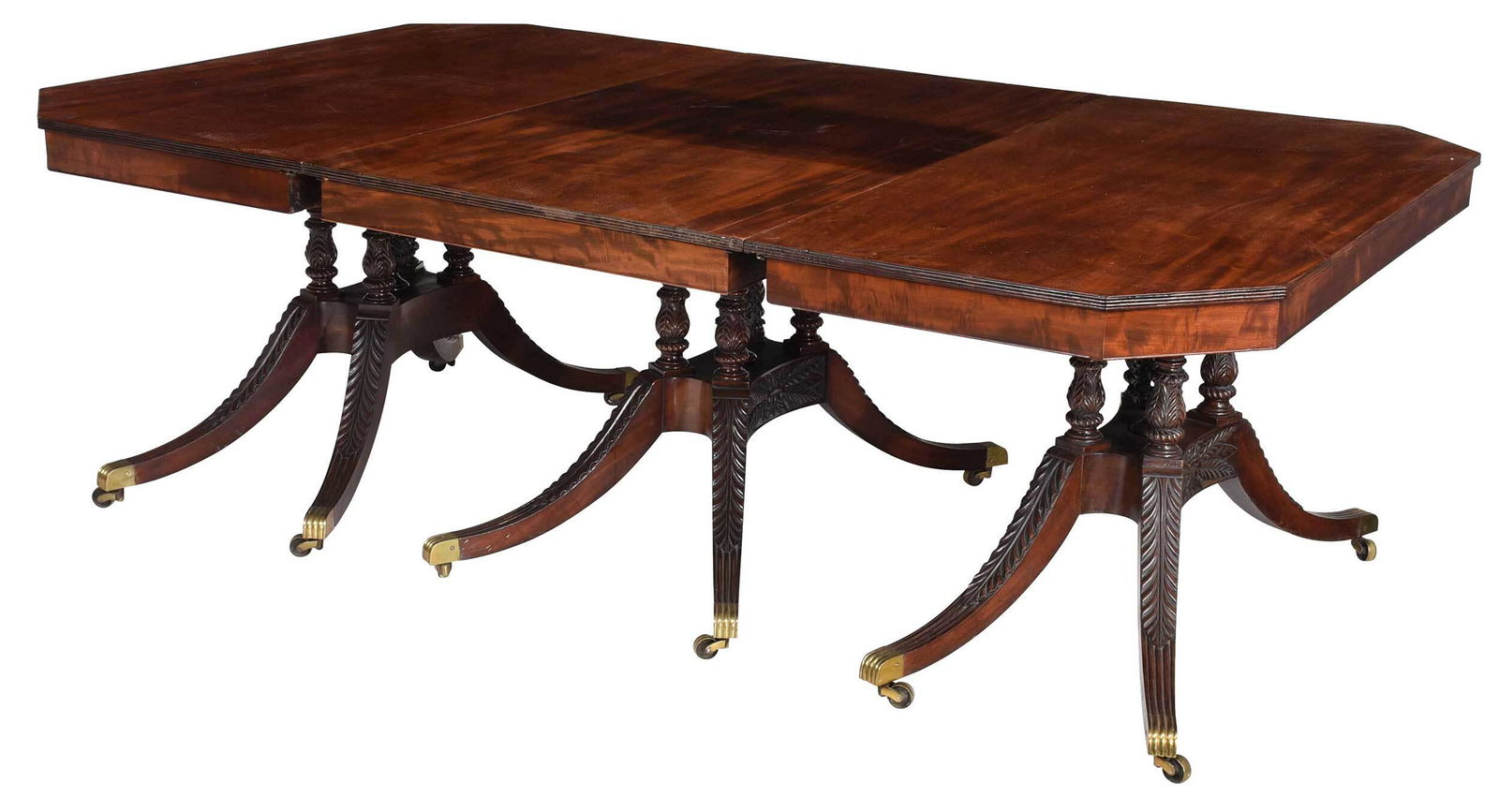 Very Fine Classical Mahogany Three Pedestal Dining Table: New York, 1815-1820, attributed to the workshop Duncan Phyfe, figured top with reeded edges and canted corners, set on finely carved and turned baluster form supports centering an artichoke finial, le