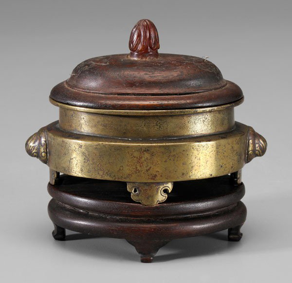 Bronze Censer: Chinese, 19th century, oval with waisted neck, lion head handles, four cloud-form feet, base with six-character Xuande mark in rectangular cartouche, wood lid with carnelian finial and wire inlay of [