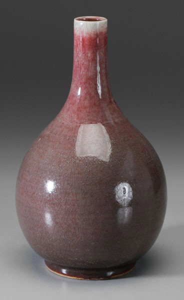 Copper-Red Glazed Porcelain Vase: Chinese, 19th century or earlier, bottle form, grayish-red with flecks of strawberry thinning to white at rim and pooling at foot, base with pale celadon glaze, 12 in., crazing, minor fritting on rim,