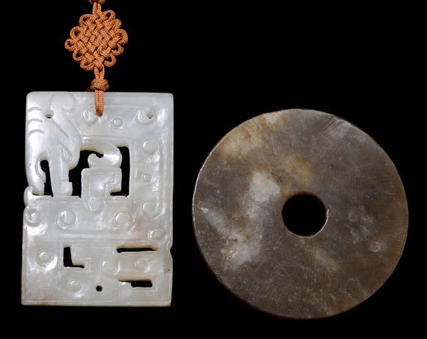 Jade Plaque, Sword Pommel: Chinese, white jade plaque, gray inclusions, coiled dragon with scroll work, 2-3/8 x 1-5/8 x 3/16 in., [very minor losses at drilled holes;] olive-brown sword pommel with white inclusions, 2-3/8 x 1/8