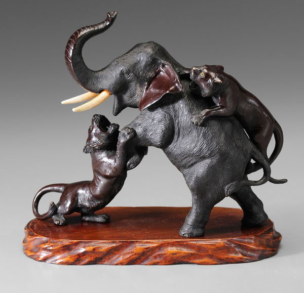 Bronze Elephant and Tiger Group: Japanese, late 19th/early 20th century, two tigers attacking an elephant, ivory tusks on elephant, glass eyes in tiger, three-character mark stamped on elephant's belly, with wooden plinth, 8-3/8 in.,
