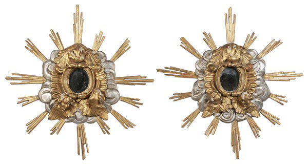 Pair Italian Baroque Style Carved and: Parcel Gilt Mirrors, Italian, late 19th century, each finely carved, parcel gilt and silvered with two winged busts set on cloud and sunburst grounds centering an oval mirror, 32 x 30 in., flaking and