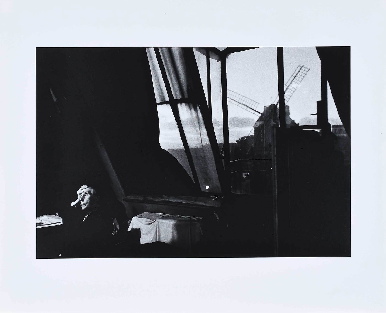 Bruce Davidson: (American, b. 1933) Interior scene with seated elderly lady and windmill, signed print verso, gelatin silver print, sheet 16 x 20 in.; unframed Provenance: Private Collection, Wisconsin