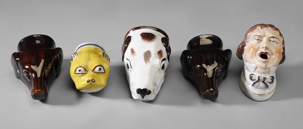 Four Stirrup Cups, Pen Holder: British, 19th century: pair brown-glazed dog heads, 4-1/2 in., [chips to ear and rim;] dog's head, white with brown accents, 4-1/2 in., [overall crazing, two 1 in. to 2 in. rim cracks;] pug dog, yello