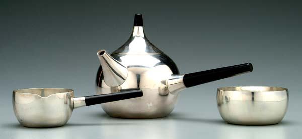 Georg Jensen three-piece tea service: onion-form teapot, 5-3/4 x 9-1/2 x 6 in.; creamer and open sugar, wood finial, no monograms, design by Henning Koppel, No. 1091, after 1945, Denmark, 26.79 oz.T. Light scratches. Provenance: Morton Co