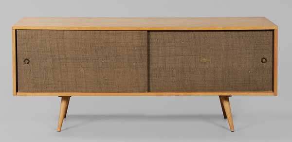 Figured Maple Two-Drawer Cabinet: back with branded mark "Paul McCobb Design Planner Group by Winchendon", fabric-clad sliding doors, 25-1/2 x 60 x 18 in., surface wear, stains and burns overall, doors with abrasions to fabric Provena