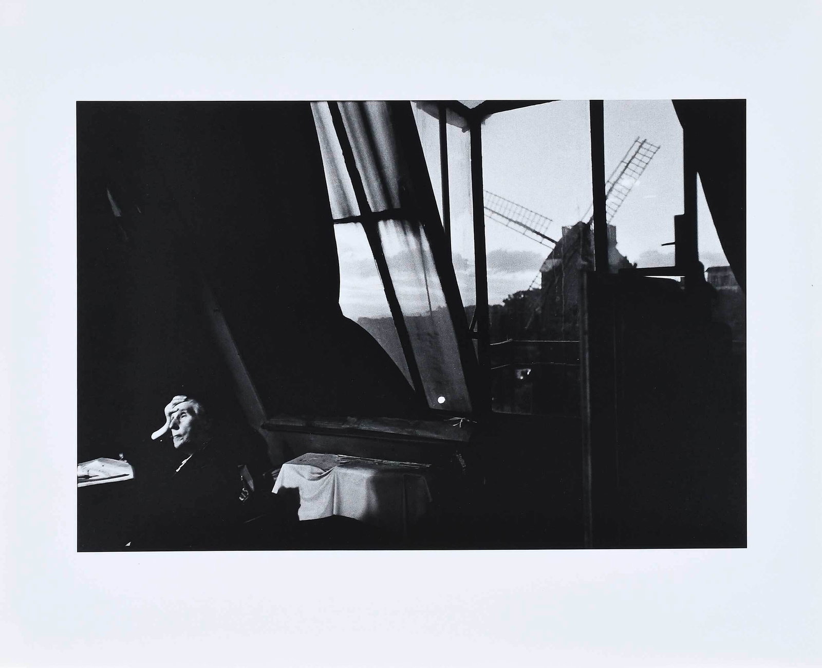Bruce Davidson: (American, b. 1933) Interior scene with seated elderly lady and windmill, signed print verso, gelatin silver print, sheet 16 x 20 in.; unframed Provenance: Private Collection, Wisconsin