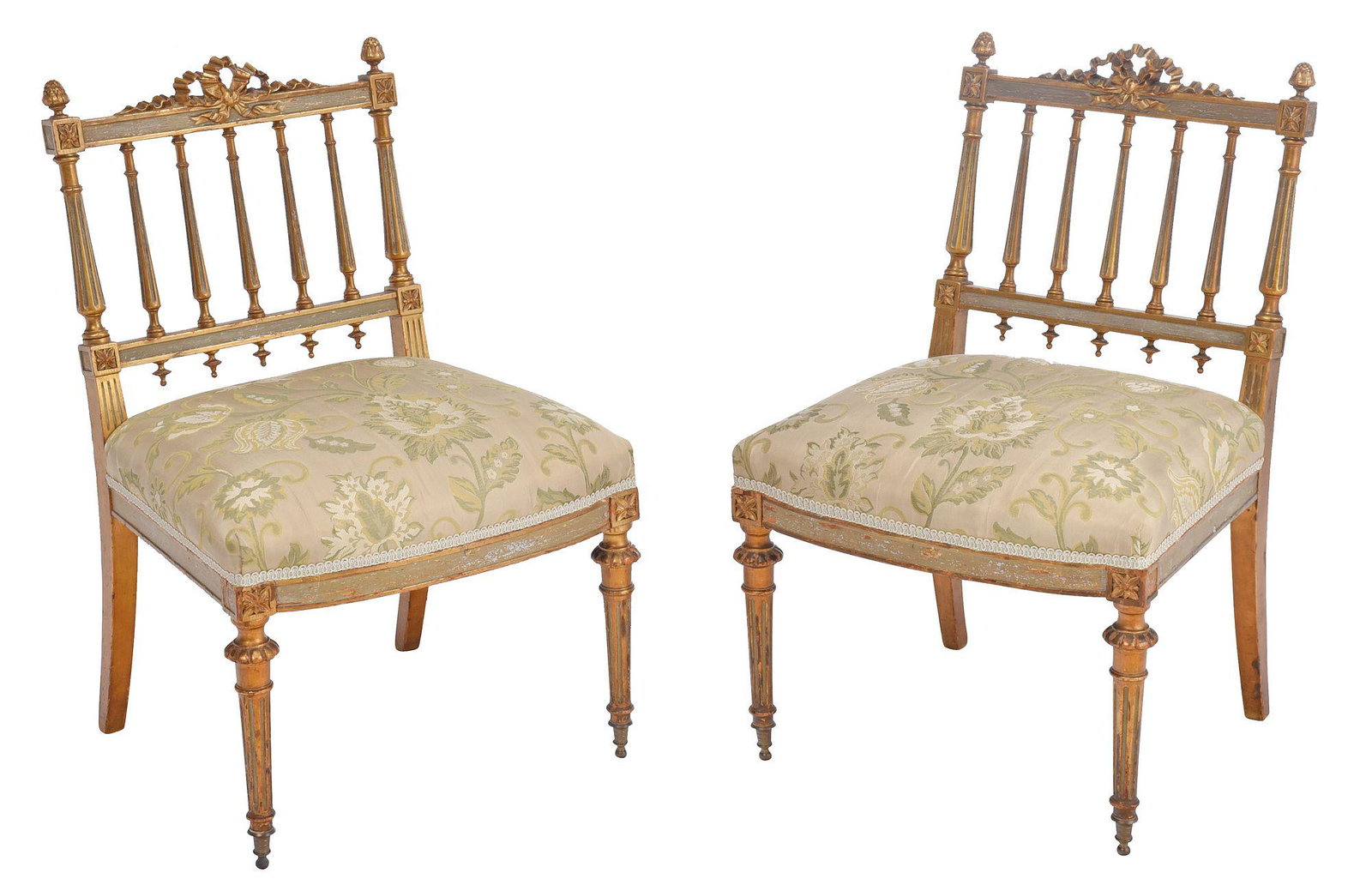 Pair of Louis XVI Style Painted and Parcel Gilt Slipper Chairs: early 20th century, surmounted by a pleated swag and foliate finials, back with fluted spindles, floral blocked rails, fluted tapered legs with brass cuffs, 28 x 18-1/2 x 16 in. Provenance: Private Co