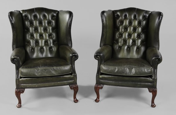 Pair Leather-Upholstered Wing Chairs: 20th century, each with dark green tufted leather upholstery with brass tacking on carved mahogany legs, 42-1/2 x 32 x 38 in.,