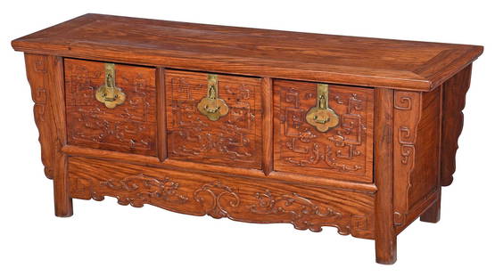 Chinese Brass Mounted Huanghuali Chest: likely 19th century, inset plank top, three drawers with scrolled relief carving, serpentine skirt and brackets, interior with Rogers collection label, 20-1/2 x 49-1/2 x 17-1/2 in. Provenance: Price a