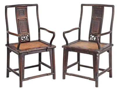 Pair of Chinese Carved Elmwood Armchairs: 19th century, serpentine crest rail, paneled splat, shaped arms, woven seat, shaped skirt surround, stretchered base, 40 x 22 x 18-1/2 in.Provenance: Gift of Zachary Taylor, now property of the