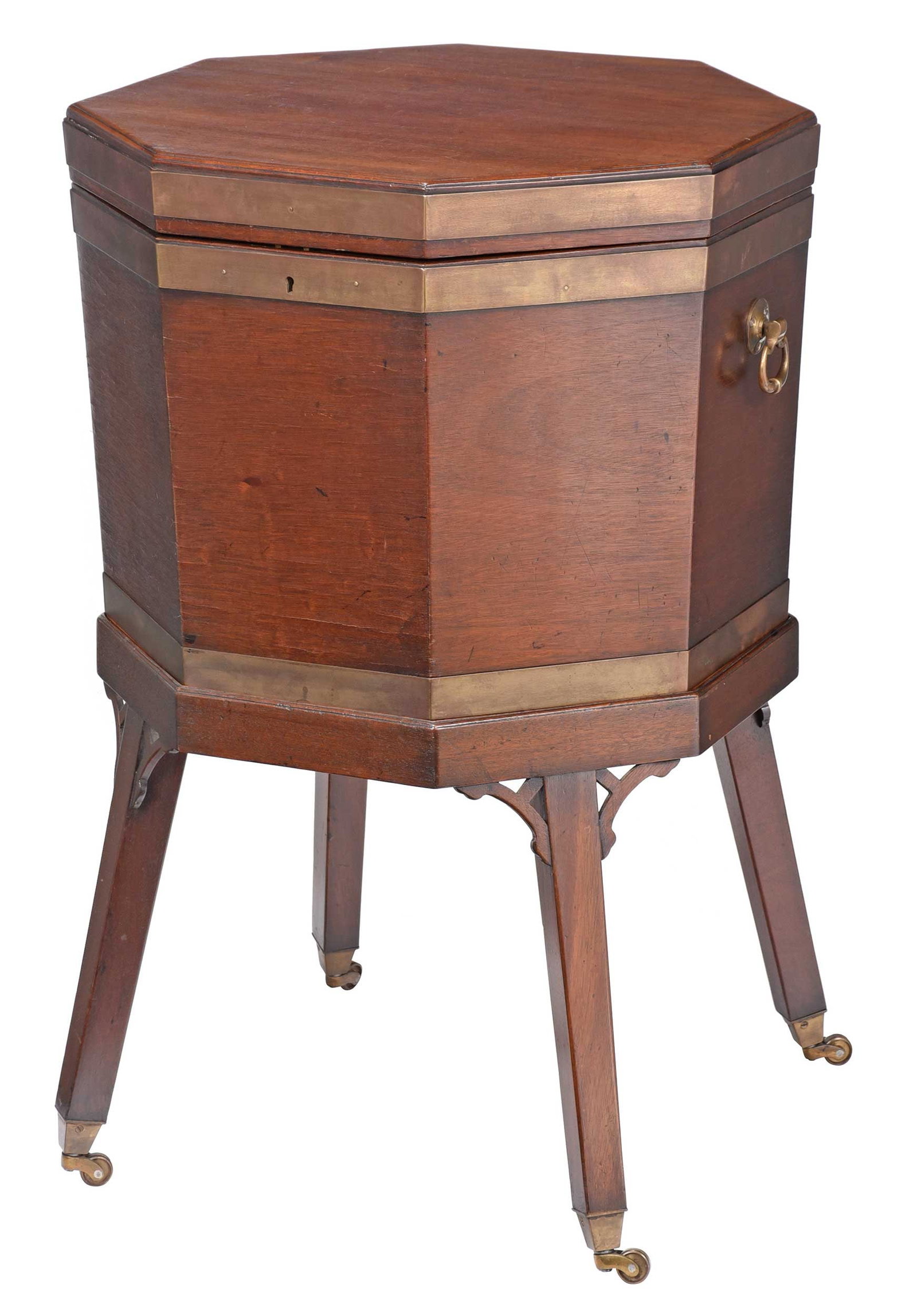 Regency Style Mahogany Brass Mounted Wine Cooler: British, late 19th/early 20th century, octagonal form with hinged lid opening to lead lined interior, conforming base with pierced corner brackets and brass casters, brass carrying handles, 32 x 20 x 