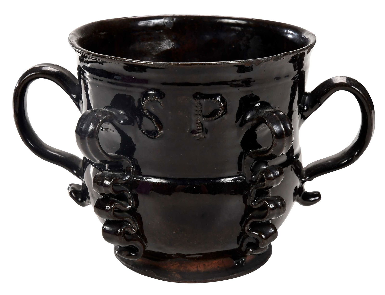 English Brown Glazed Earthenware Cup: circa 1690-1710, set with scroll handles, the front with the applied initials "SP", flanked by applied strips of ruffled clay, 6-1/4 in. Provenance: Property from the Collection of Dudley and Constanc