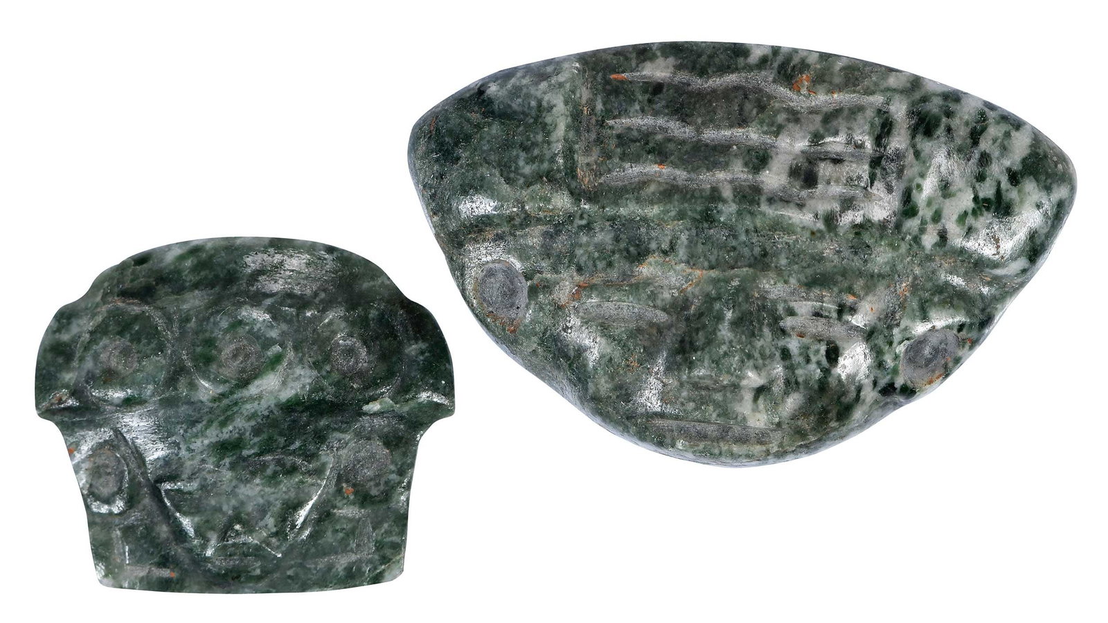 Two Mesoamerican Carved Jade Heads: possibly Pre Columbian, acquired prior to 1944, both green with whitish inclusions, stylized faces, larger 1-3/8 x 2 in. Provenance: Estate of William E. Hughes, San Antonio, Texas; by descent in fami