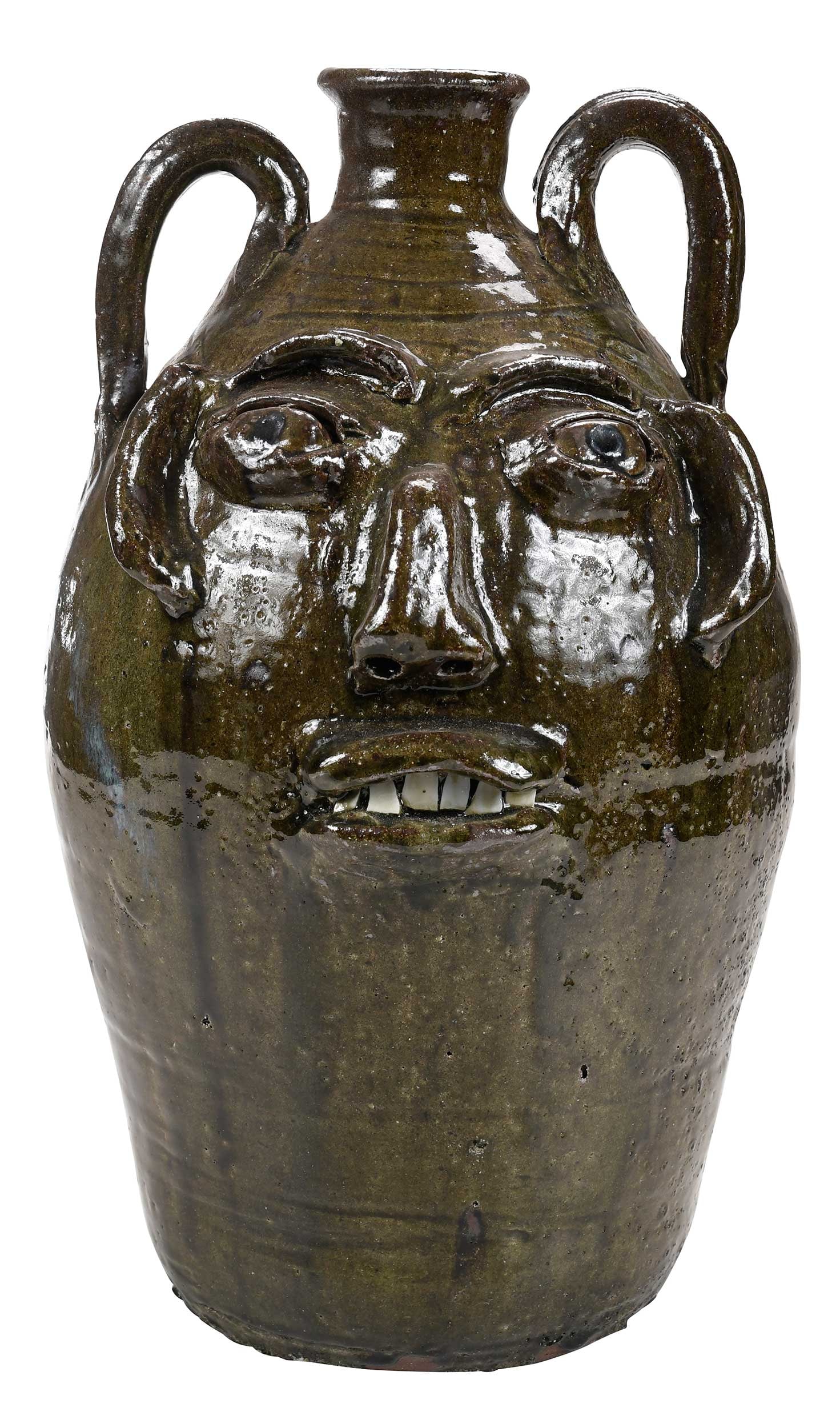 Large Signed Burlon Craig Face Jug: (Vale, North Carolina, 1914-2002) runny olive green alkaline glaze, rutile runs to one side of jug and other locations, applied facial feature, broken china teeth, cobalt pupils, alternating wavy line