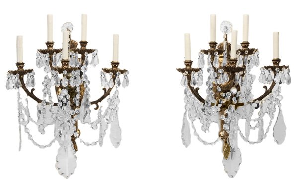 Pair of Crystal and Brass Sconces: each hung with cut glass pendants and swags, electrified, 20 x 16 in., several prisms missing or chipped, some others off but present, some surface and casting flaws Provenance: Estate of the Late Joh