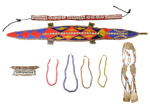 Eight Pieces Jewelry and Decorative: Accessories African and Tibetan, 20th century: four African beaded necklaces, cowry shell and beaded belt, cowry shell and beaded alligator-form wall hanging, Tibetan brass and beaded belt and necklac