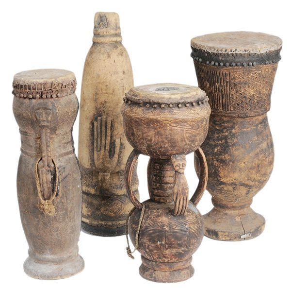 Four Carved Wood Tribal Drums: African, 20th century: Kuba and Bakuba tribes, each with hide-covered top, patinated surfaces, 23 in. to 30-1/2 in., punctures and damages to hide, surface wear, cracks and scattered repairs throughou
