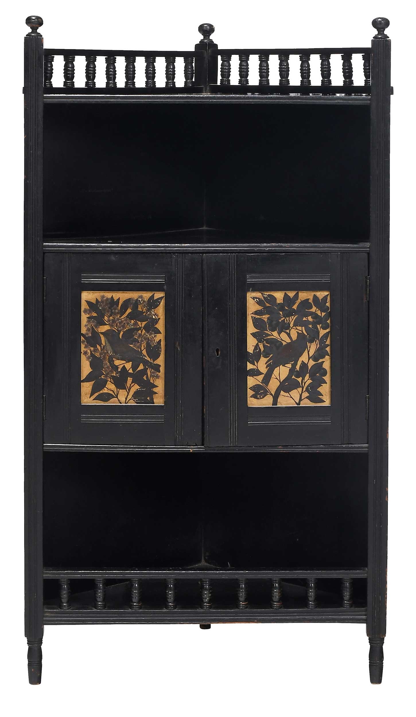 An Aesthetic Movement Ebonized Gilt and Paint Decorated Small Corner Cabinet: attributed to E. W. Godwin circa 1870s, ebonized case with galleried top and base, two songbird and foliate decorated painted and gilt paneled doors, open interior, turned legs, 41-1/2 x 22 x 14-1/2 i