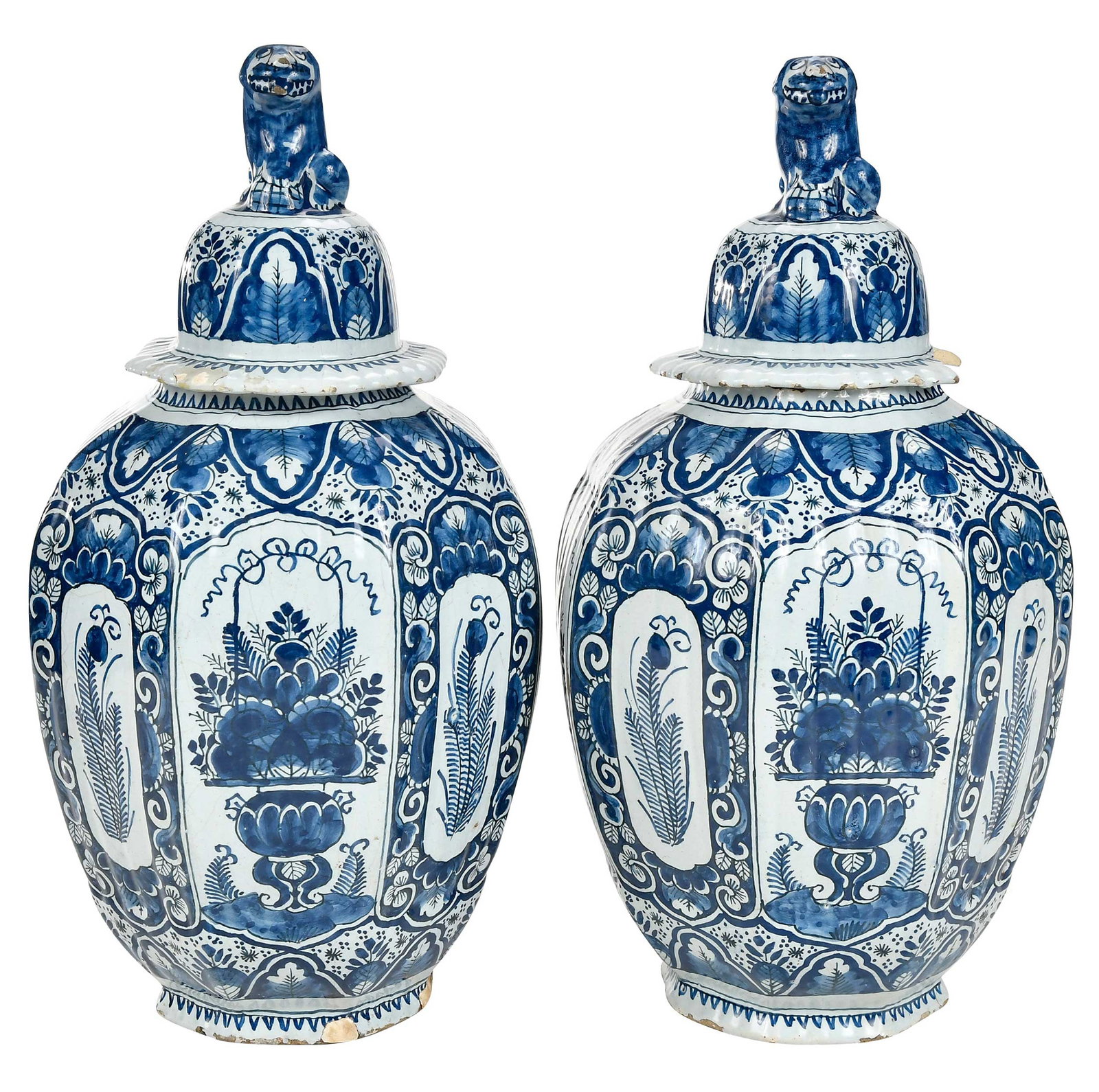 Pair of Dutch Delft Blue and White Lidded Jars: possibly 18th century, paneled and ribbed bodies, floral and peacock feather decoration, lids in matching design with lion finials, each approximately 16-1/4 x 8-3/4 in. Provenance: Estate of Paul W.