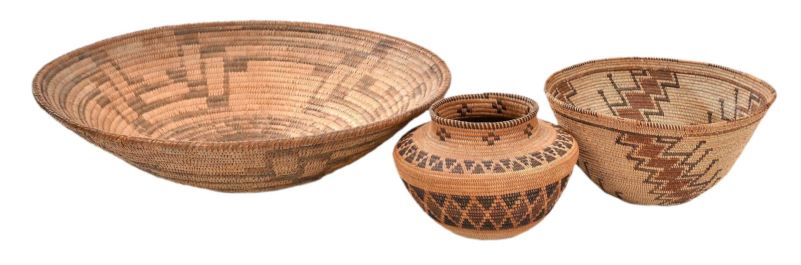 Three Coiled Polychrome Baskets: late 19th/early 20th century, the largest a coiled tray, possibly Pima, with black center, geometric decorations, 4 x 14-1/4 in.; the second a storage bowl, possibly Yokut, 20th century, with connecte