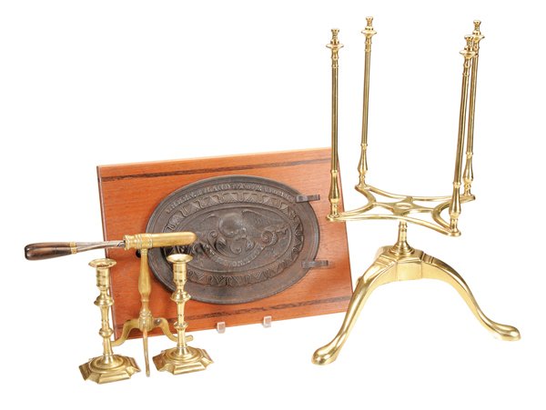 Five Brass and Iron Articles: 18th through 20th centuries: early pair brass candlesticks, 8 in., [repairs at stems with some resoldering;] curling iron on brass tripod base, 9 x 11 in.; revolving brass plate rack, probably 20th ce