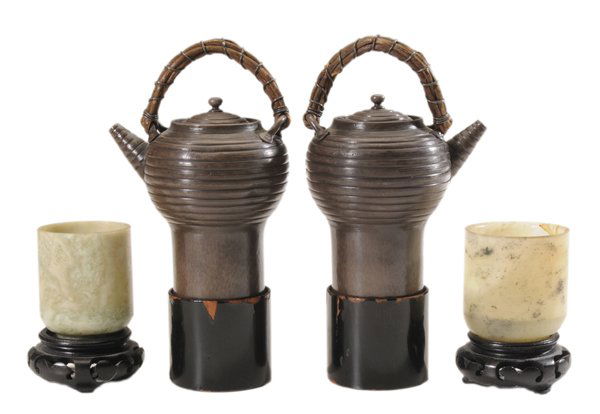 Japanese Teapots, Coasters, Hardstone: Cups 20th century: pair Japanese teapots, brown enamel over silver, removable covers, woven grass loop handles applied to spiral-banded body with expanded bottom, seated in black-lacquered coasters, e