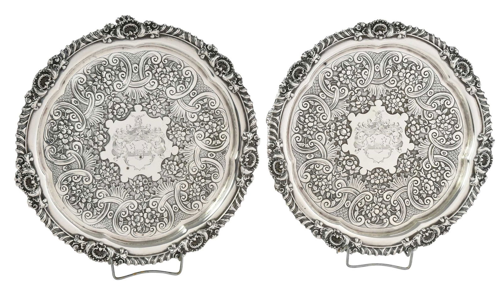 Pair George III English Silver Salvers, Robert Hennell: London, 1818, round with gadroon and shell borders, later scroll and floral decoration on the floor, paw feet, heraldic device, marks for Robert Hennell II, .925 fine, 45.88 oz. T., 10 in. Provenance:
