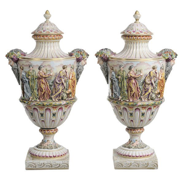 Pair Capodimonte Porcelain Lidded Urns: Continental, 20th century: Bacchus head handles, classical figures in an exterior setting, extensive gilt highlights, 22 in., both lid finials repaired. Provenance: Property of a Tennessee Collector