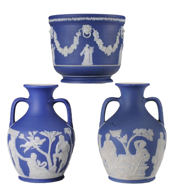 Three Pieces Wedgwood Jasperware: English, late 18th/early 19th century, each with classical figures on dark blue ground: two Portland vases, both with impressed Wedgwood marks, 8 in. and 8-1/4 in., [largest with retouched rim chip an