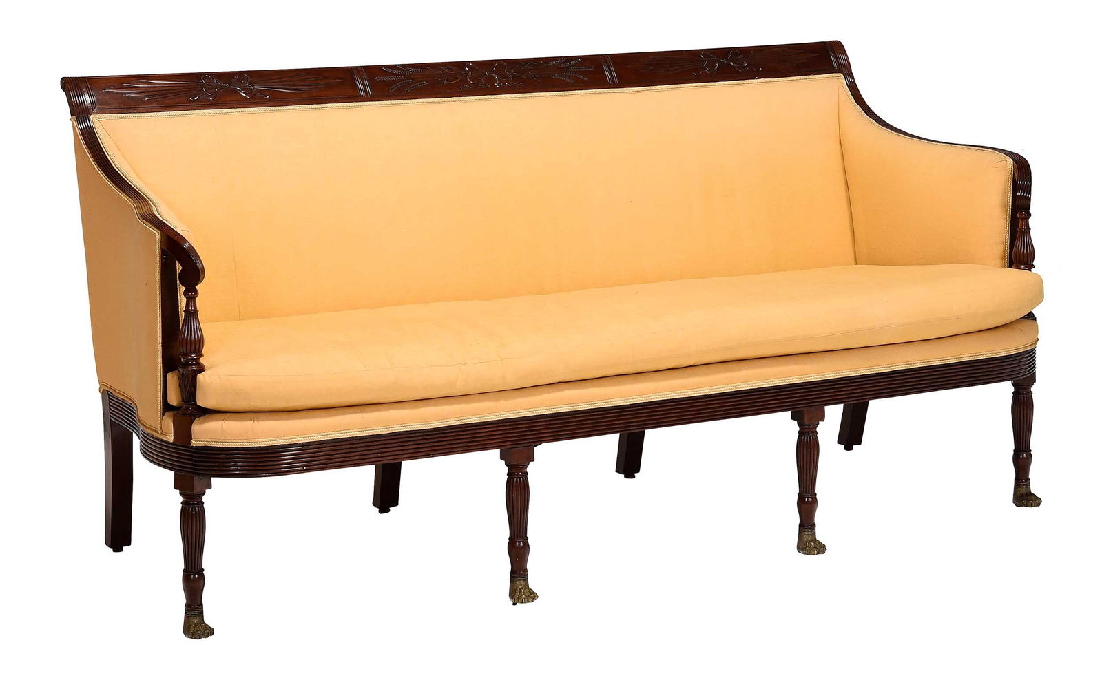 Fine Classical Carved Mahogany Compass Seat Sofa: New York, circa 1815, attributed to the school of Duncan Phyfe, brass paw front feet, yellow upholstery, 37-1/2 x 77 x 32 in. Provenance: Collection of Edward Vason Jones; Virginia F. White Interiors,