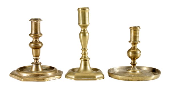 Three Early Brass Candlesticks: English, 17th to 19th centuries: one with central ring ball turning and circular drip pan, possibly 17th/probably 18th century, 4-1/2 x 5 in., [slight dent to nozzle at top, small hole in pan;] one oc