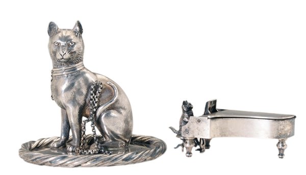 Two English Silver Cat Figures: match safe depicting cat at piano, top of piano lifts to hold matches and striker, marks on top of base for James Freeman, London, 1892, 1-3/4 x 4 x 1-3/4 in., [lid slightly sprung;] figural cat with 