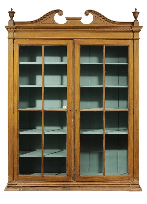 Architectural Faux-Painted Bookcase/: Cabinet British or American, second half 19th century, pine throughout with removable broken-arch pediment with urn outer finials over dentil-molded cornice, probably original mustard combed paint dec