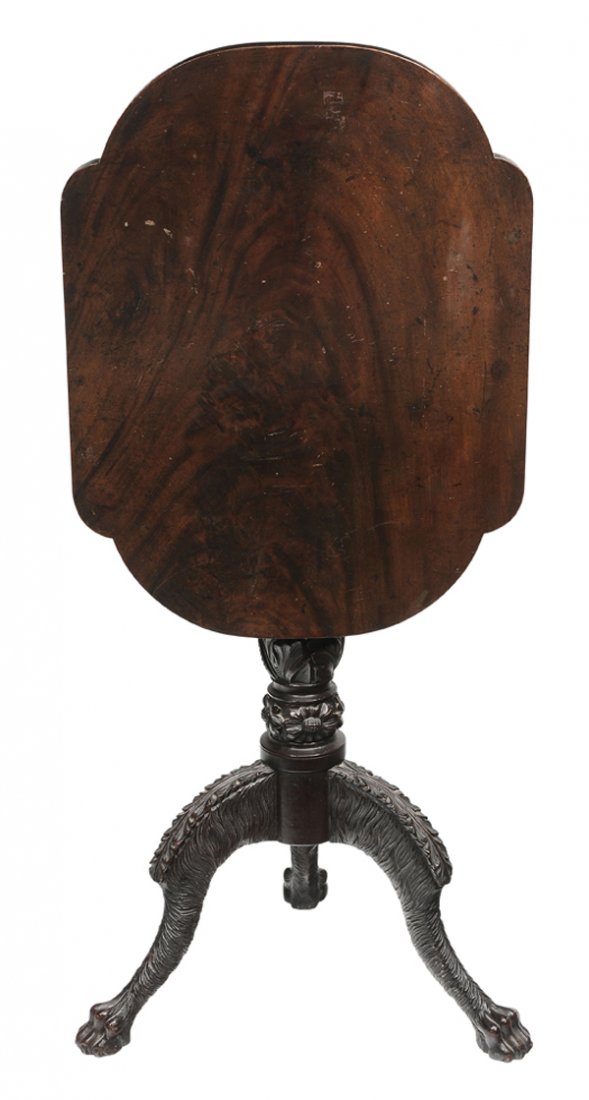 American Classical Carved Mahogany: Tilt-Top Candle Stand probably New York, 1815-1825, highly figured single-board top on leaf-carved support, tripod base and leaf and hairy carved legs on paw feet, old surface with rich brown color, 3