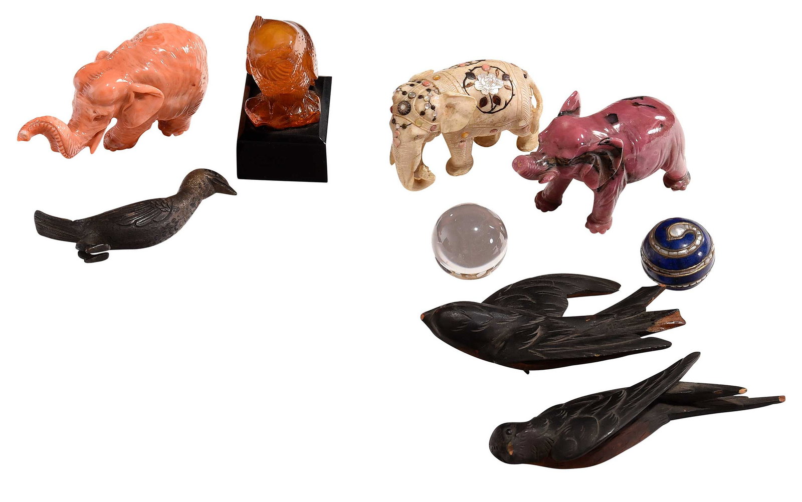 Nine Decorative Table Objects, Animals and Spheres: most with tags attributing Russian origin, comprising: carved rhodochrosite elephant, carved bone elephant, carved glass/imitation coral elephant, carved owl, two carved wood bird decorations, metal b
