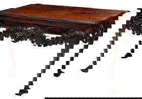 Highly Important Irish George II Carved Mahogany Side Table: The Devenish Table: circa 1755, figured top with a molded edge, deeply carved latticework skirt with foliate swags, the front skirt centering a robustly carved lion mask with protruding tongue and wild crisply carved flo