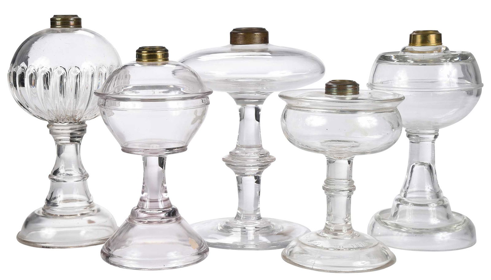 Five Clear Stemmed Glass Fluid Lamps: 19th century, various forms, all but oblong example with Thuro Collection labels to bases; largest approx. 10-1/2 x 6 x 6 in. Provenance: (oblong example) Richard A. Bourne Co., Inc., Hyannis Port, Ma