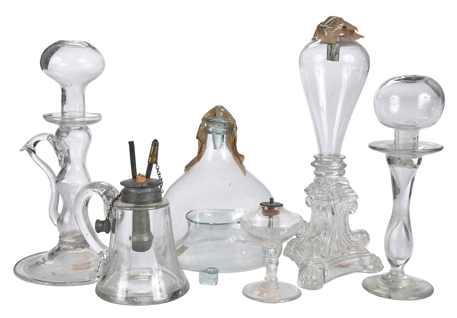 Five Early Clear Glass Lighting Implements, With Fly Catcher: comprising: five glass fluid lamps, various forms and origins, molded base example with French attribution; fly trap; largest 11 x 4-1/2 x 4-1/2 in. Provenance: (fly trap and molded base lamp) Richard