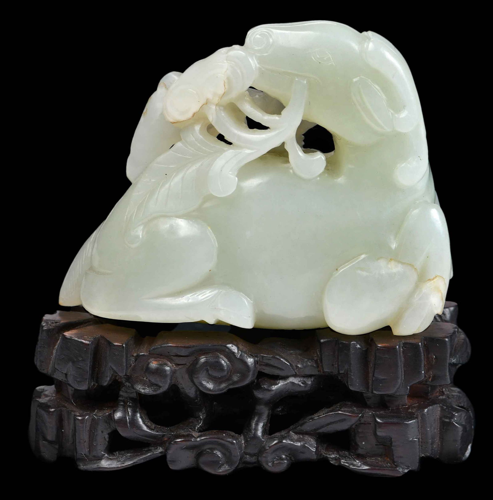 Chinese Carved Jade Recumbent Deer: with receipt that reads "Chien Lung Mutton fat white jade recumbent...", sacred deer holding branch of lingzhi in its mouth, incised with two characters to underside, with carved custom hardwood stand