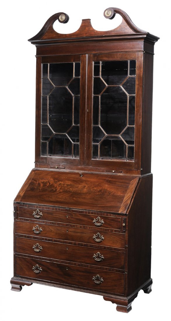 George III Style Inlaid Mahogany Desk: and Bookcase British, 19th century, scrolled pediment over two glazed doors with adjustable shelved interior, lower case with fitted desk interior, prospect door inlay of Britannia, ogee bracket feet,