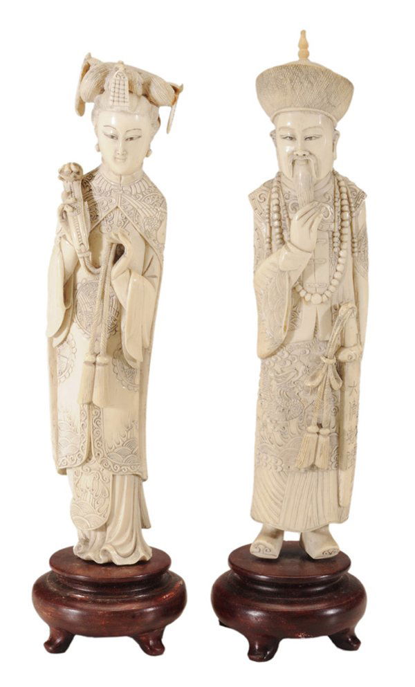 Pair Carved Ivory Standing Figures,: Emperor and Empress Chinese, early to mid 20th century, standing figures elaborately carved and decorated in royal attire, he wearing a sword, beads and elaborate robe with hair braided, one hand behi