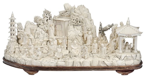 Monumental Ivory Figural Scene, 18: Buddhist Saints Chinese, 20th century, mountain scenery with 18 immortals from Buddhist realm, figures attached to platform, temple entrance with guardian, dragon in clouds, reverse with rocky mountai