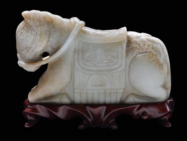 Carved Jade Horse: Chinese, 19th century, nephrite, mottled white and tan, caparisoned seated pony, in the Mongolian style, simply carved on both sides, low polish, saddle with scenes of rocks, waves, and stirrups, 4 x 