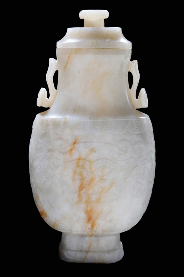Jade Lidded [Hu]-Shaped Vase: Chinese, 19th century, jadeite in translucent mottled white, tan and gray with rind being used as accent color, carved on two sides with magic fungus, [ruyi] handles, [taotie] masks in low relief and 