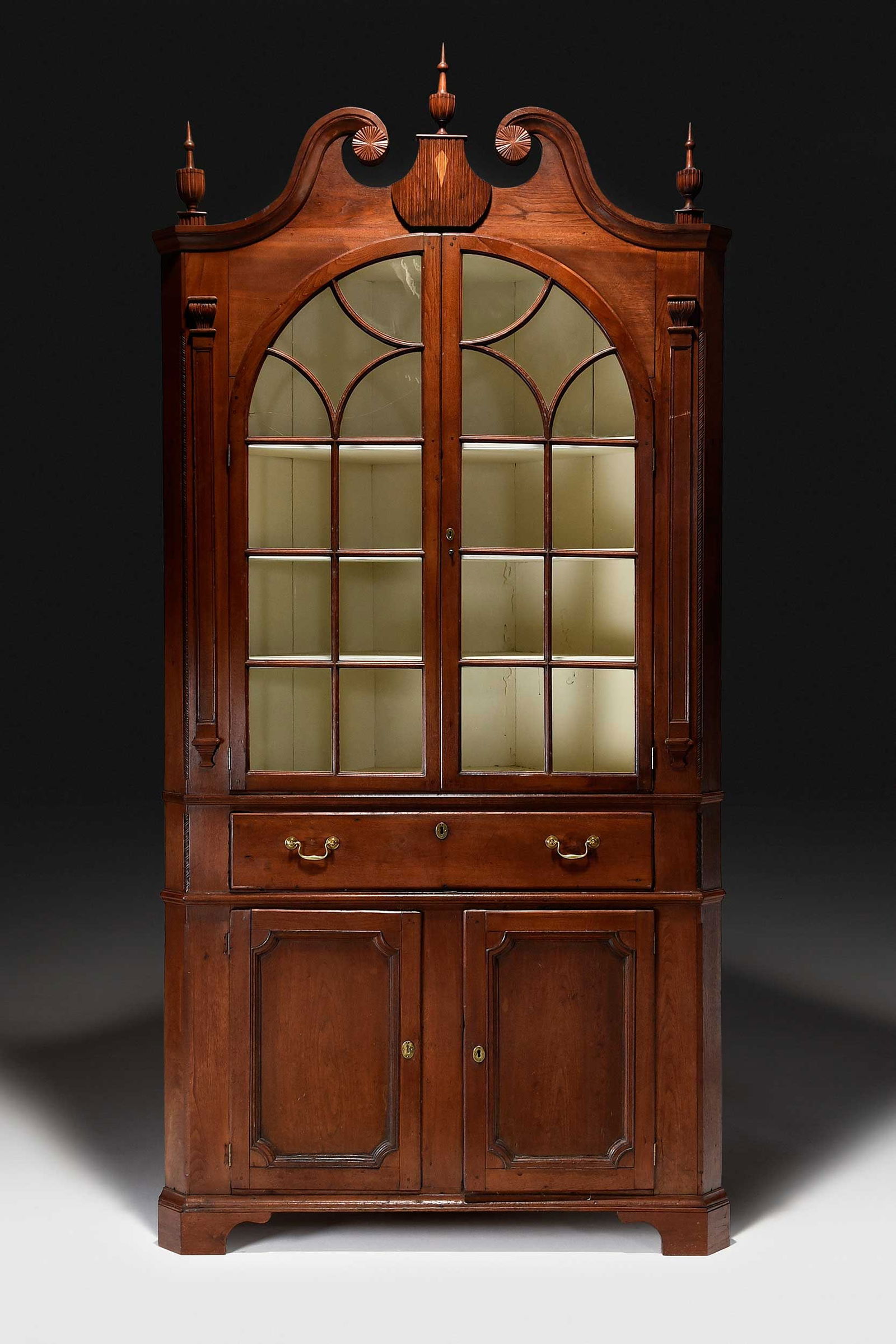 Swisegood School North Carolina Federal Carved Walnut Corner Cupboard: attributed to the John Swisegood school, possibly Mordecai Collins, Davidson County, North Carolina, early 19th century, yellow pine secondary, single case construction with scrolled pediment centerin