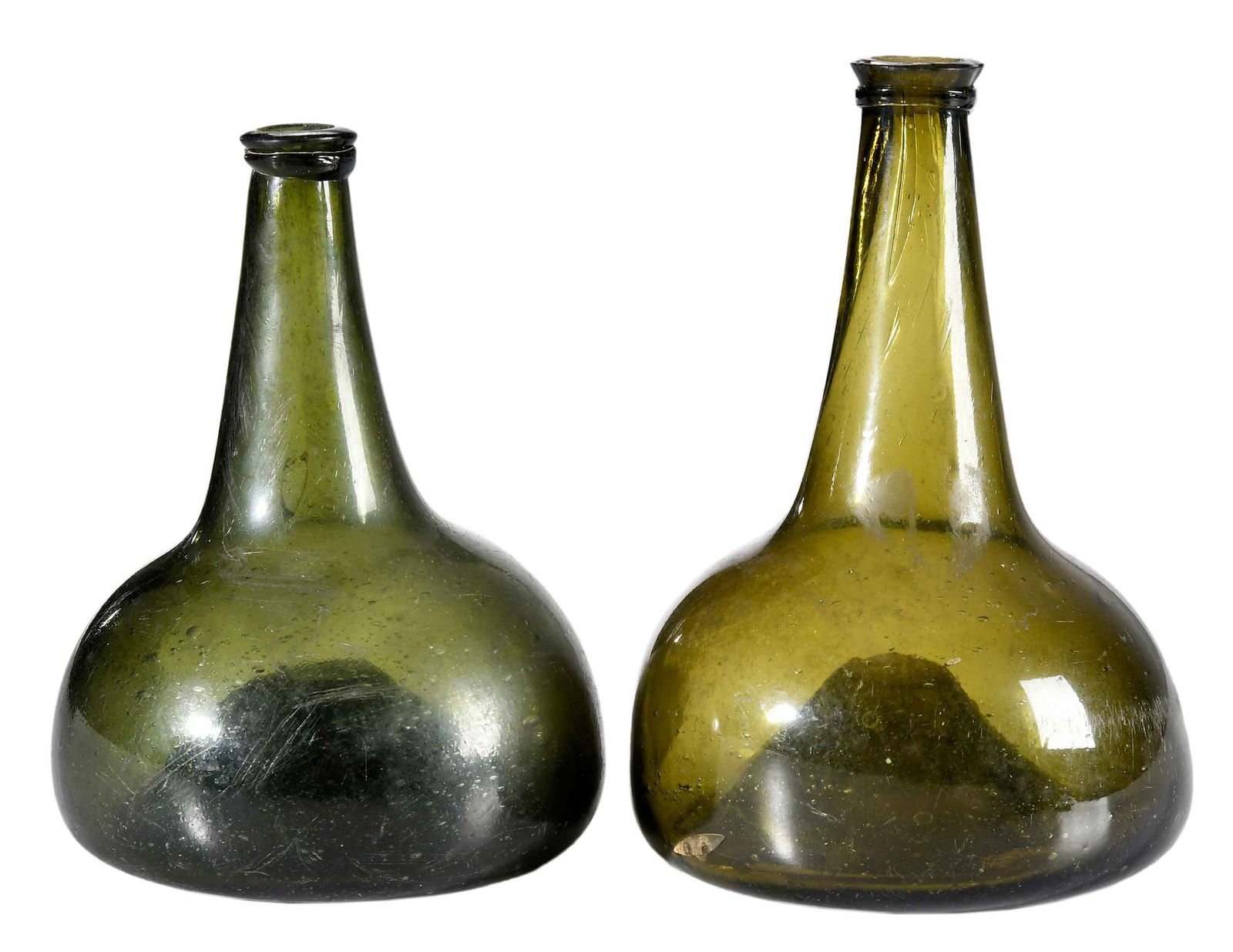 Two Early Olive Green Blown Glass Wine Bottles: 18th century, unmarked, larger 8 x 5-1/2 x 5-1/2 in.Provenance: Estate of Joe and Betsy Byerly, Greensboro, North Carolina 
